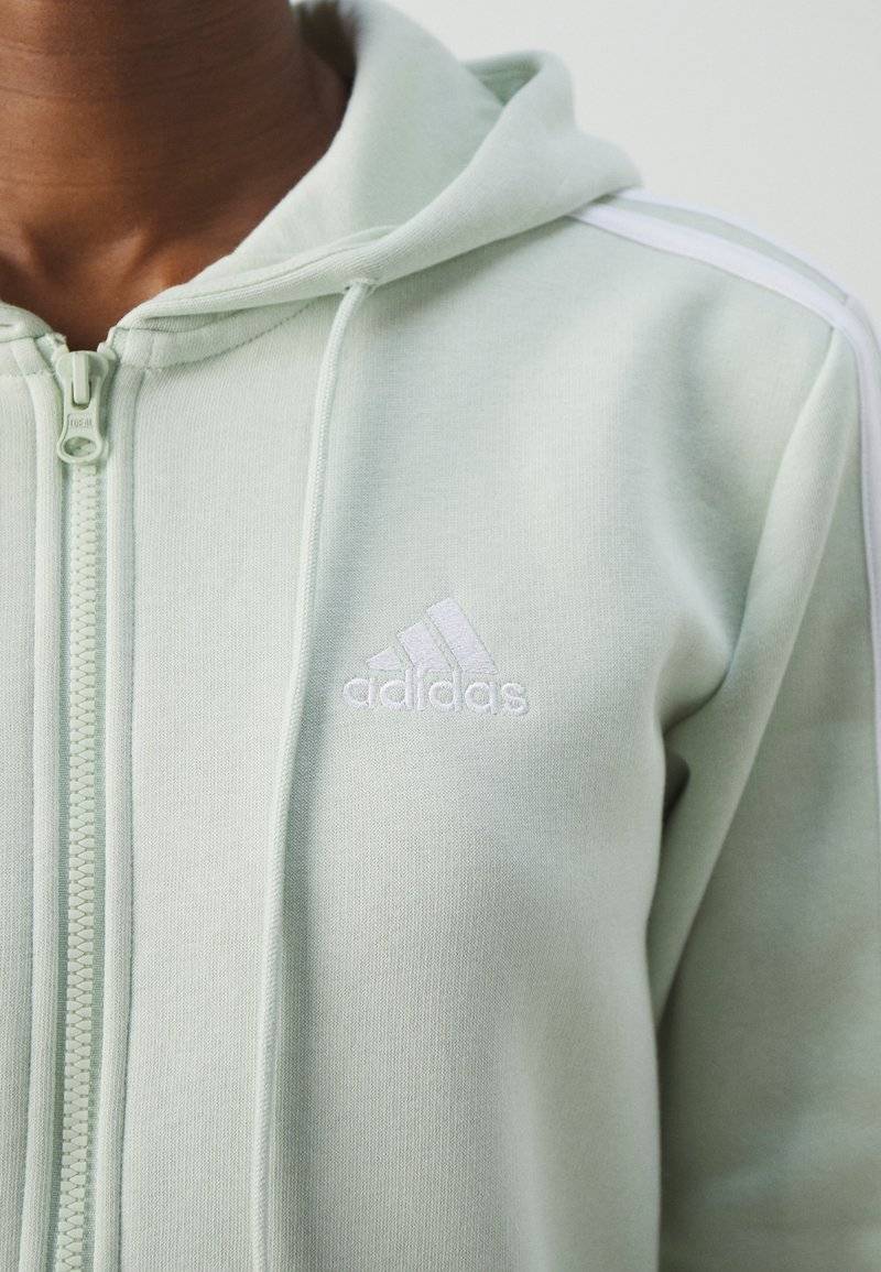adidas Sportswear adidas Sportswear ESSENTIALS 3 STRIPES FULL ZIP HOODIE - Zip-up sweatshirt - linen green Fabrikladen